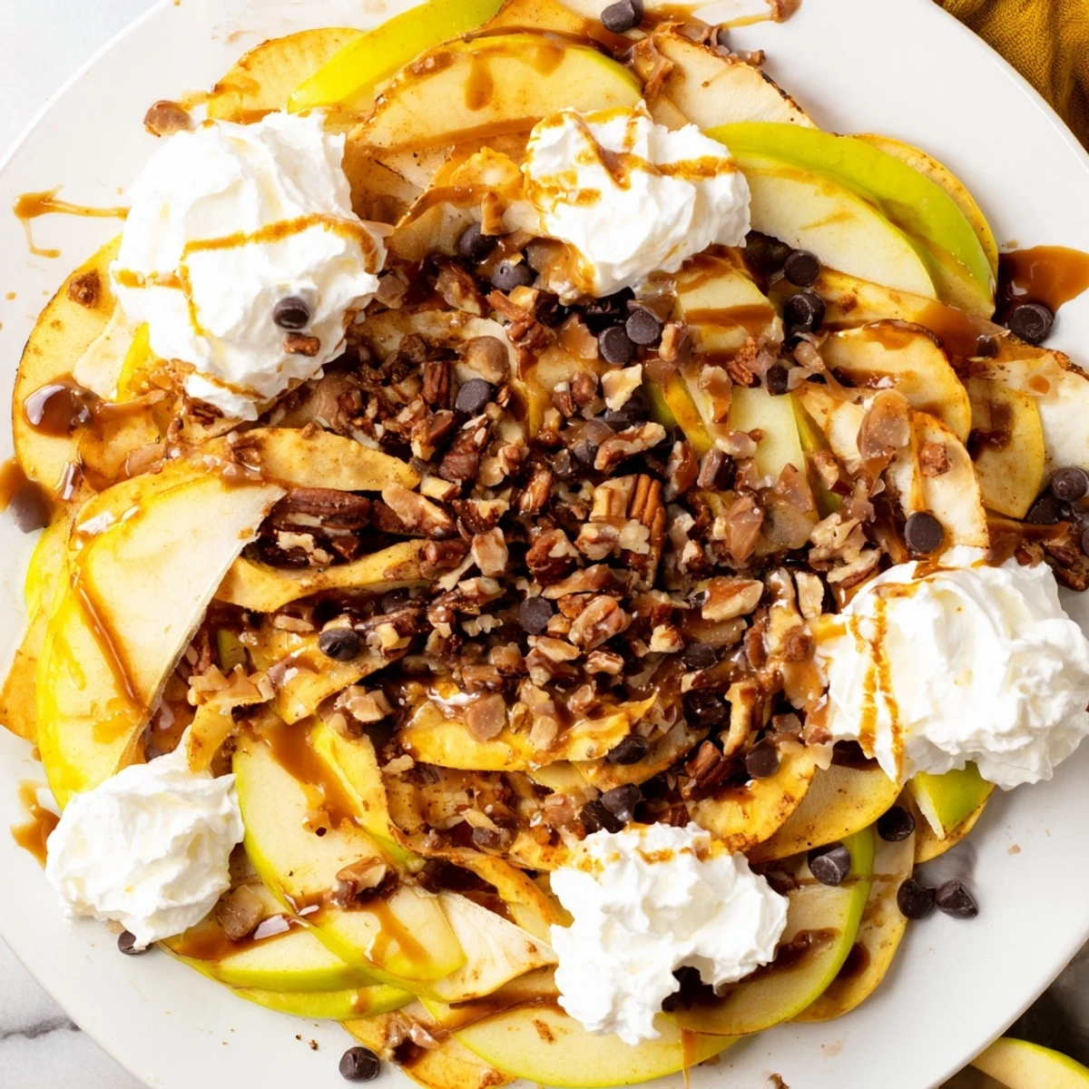 Loaded Caramel Apple Nacho Platter topped with creamy caramel and crunchy nuts.  