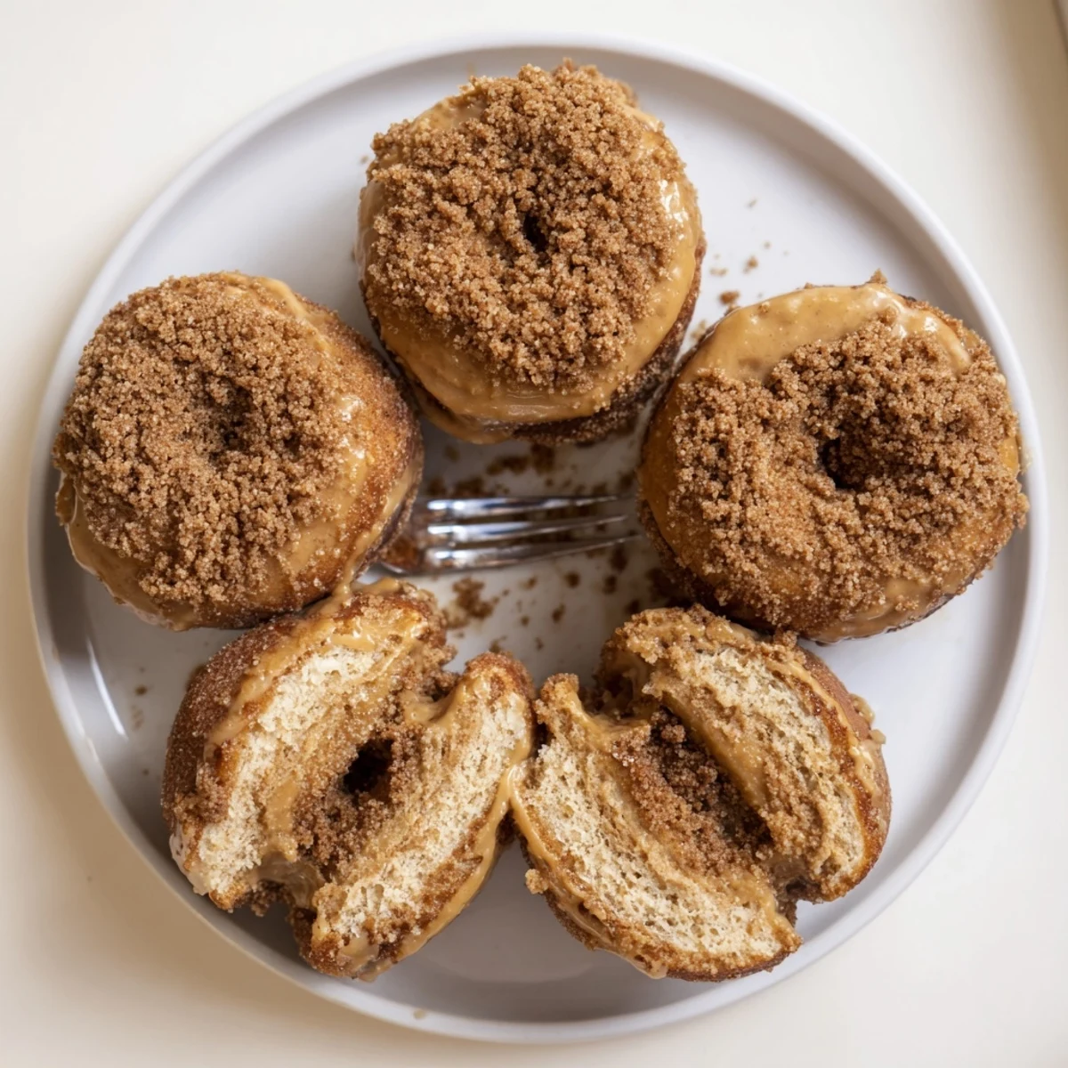 Soft Apple Butter Cinnamon Crunch Donuts glistening with sweet cinnamon topping on a white plate.  
