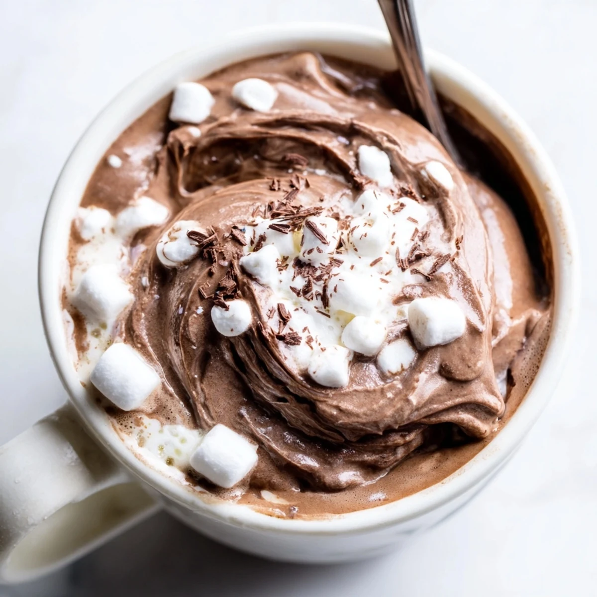 Whipped hot chocolate drink garnished with chocolate shavings, inviting and deliciously sweet.