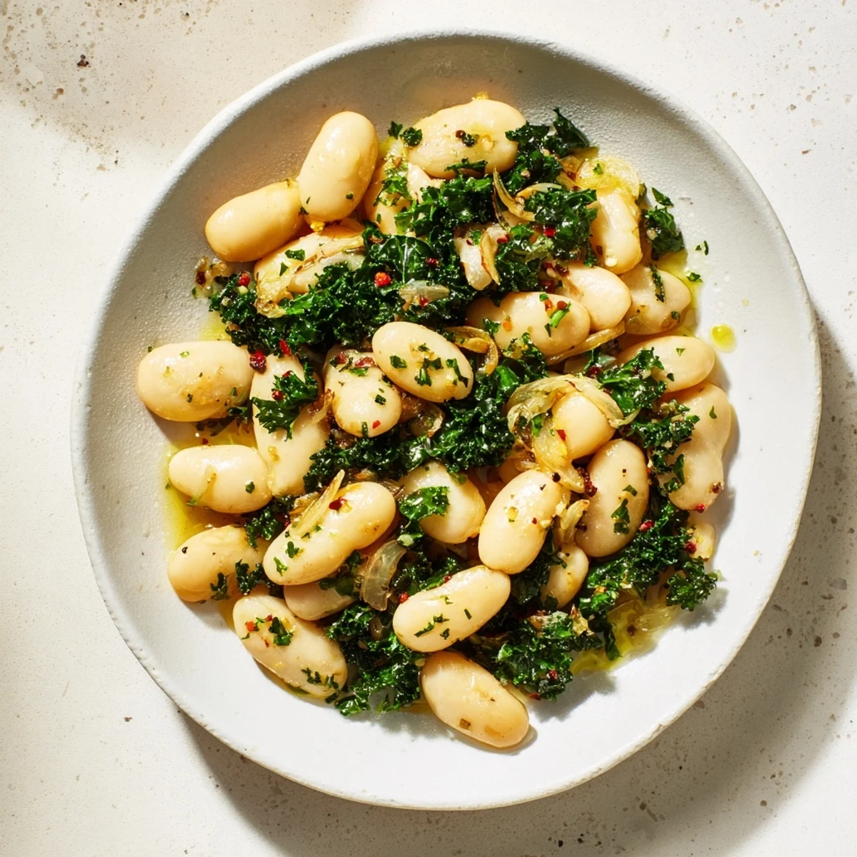 Golden garlic coats creamy cannellini beans and winter greens in this delicious Garlicky Beans recipe.