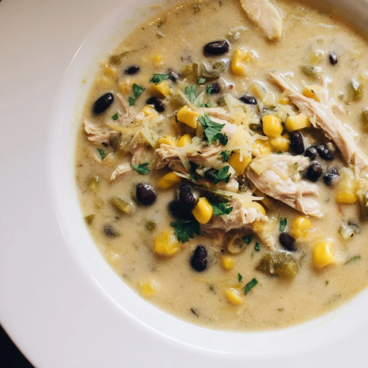 Steaming bowl of Chicken Poblano Soup, garnished with cilantro, ready for a comforting meal.