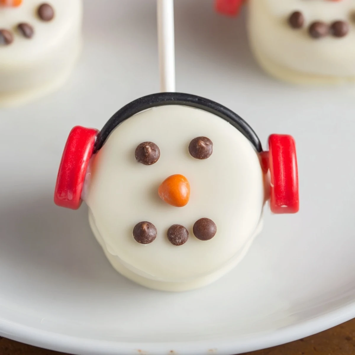 Adorable Budget-Friendly Oreo Snowman Pops: chocolate-covered cookies decorated as festive winter treats.