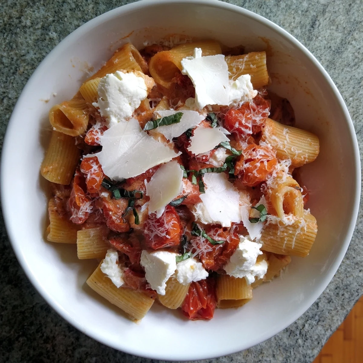 This inviting image shows the delicious Four-Cheese Baked Block Pasta, ready to serve with fresh basil.