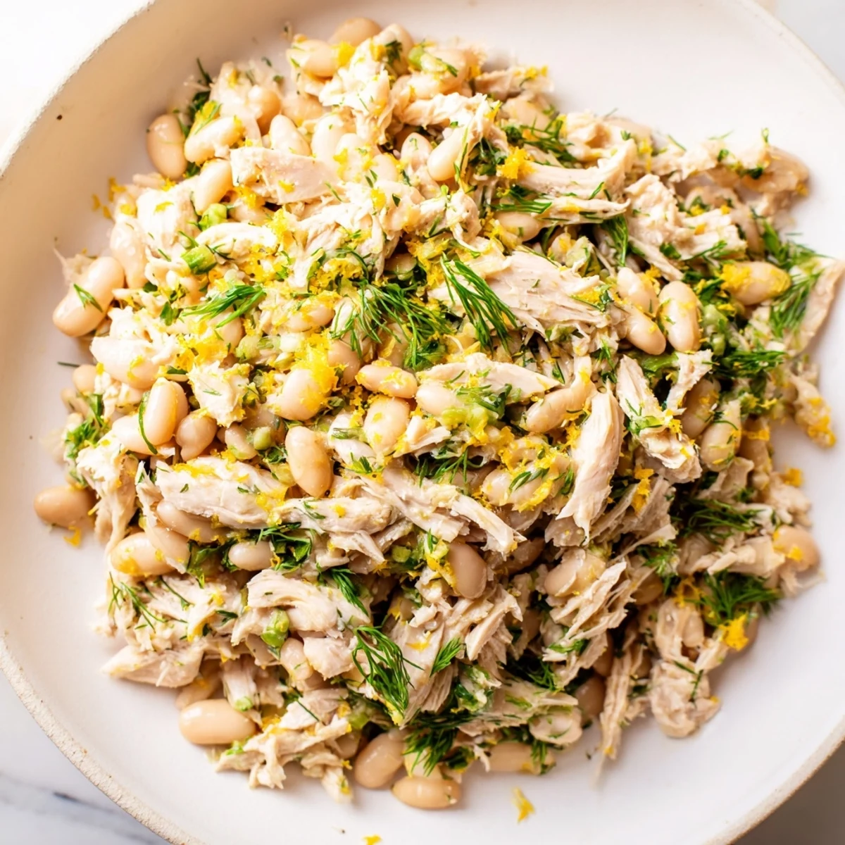 Bright white beans and tender shredded chicken mingle with crisp celery and fresh herbs in a vibrant Lemony White Bean Chicken Salad, tossed in a zesty lemon vinaigrette.  