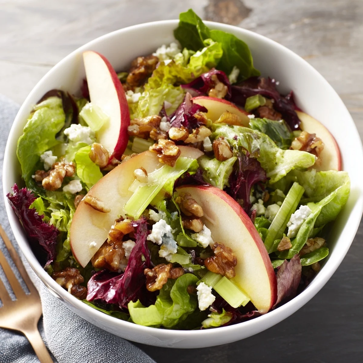 Freshly tossed Apple and Walnut Salad with crisp apple slices, celery, and toasted walnuts on a bed of mixed greens, drizzled with tangy vinaigrette.