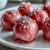 Chilled Oreo Truffle Balls are dipped into smooth pink candy melts and finished with festive sprinkles.