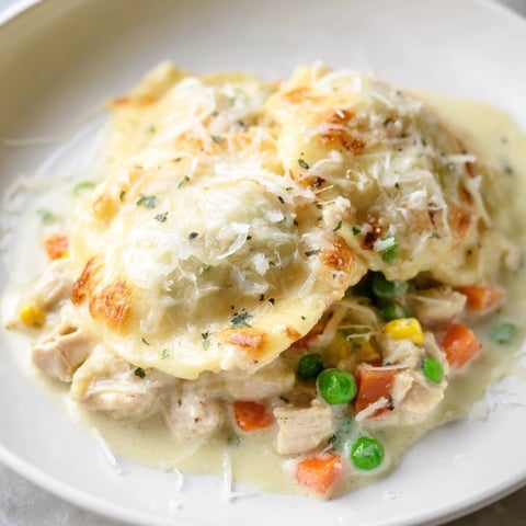 Golden, bubbly Chicken Pot Pie Ravioli Bake with melted cheese, a comforting family dinner ready to serve.