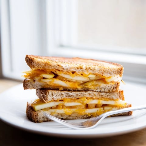 Golden, melted Caramelized Onion, Apple & Cheddar Grilled Cheese, perfectly sandwiched and ready to slice.