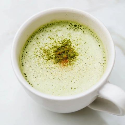 Steaming mug of Coconut Ginger Matcha Winter Immunity Latte, garnished and ready to sip on a cozy day.