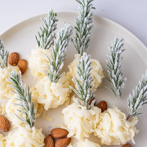 A frosted pine cheese platter, featuring cheddar snowdrifts and rosemary pines, ready to serve.