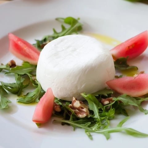 Artfully arranged The Zenith Point salad with creamy cheese wheel centerpiece, ready to serve and impress.