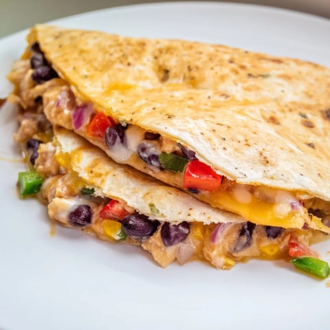 Golden-brown Black Bean Quesadilla, filled with melted cheese, spices, and savory black beans, ready to eat.