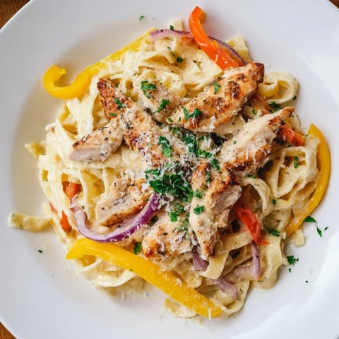 Tender Cajun Chicken Pasta with creamy sauce, colorful peppers, and fresh parsley garnish.