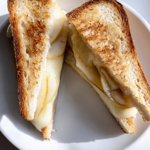 Golden grilled Brie and Apple Grilled Cheese with melted cheese oozing from toasted sourdough.