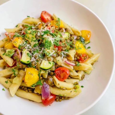 Steaming Lentil Pasta with Vegetables: a colorful Mediterranean main course, seasoned with fresh herbs.