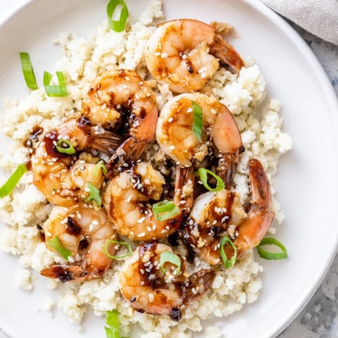 Steaming ginger garlic shrimp bowls served with vibrant green onions and toasted sesame seeds, ready to eat.