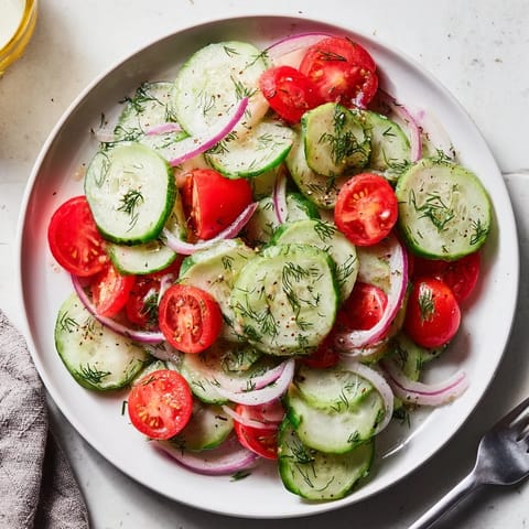 Vibrant marinated cucumbers, onions, and tomatoes tossed in tangy vinaigrette, ready to enjoy.  