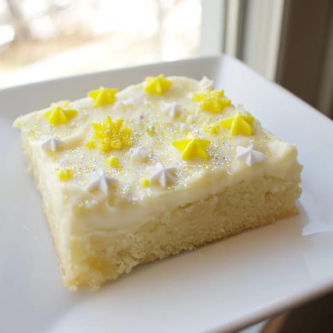 Twinkle Twinkle Star Dessert Bars showcase golden shortbread topped with vanilla frosting and festive sprinkles.