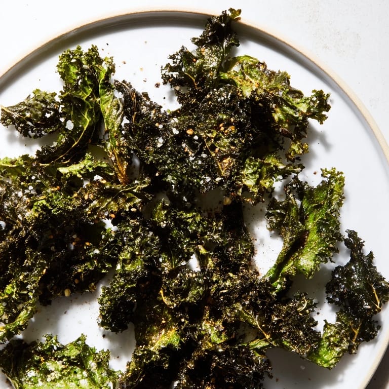 Freshly prepared, crispy baked kale chips, a quick and easy American vegan snack to make.