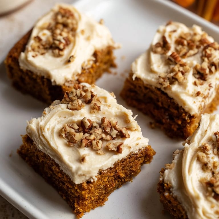 A close-up of frosted pumpkin bars, inviting with the smell of cinnamon and nutmeg.
