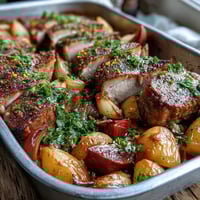 Freshly roasted Pork and Aromatic Rhubarb Traybake features tender pork slices and glazed rhubarb spears alongside caramelized red onion wedges. Fresh parsley garnish is visible on a dark serving platter, perfect for an easy weeknight dinner.