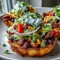 Crispy potato taco bowls brimming with colorful taco filling and fresh toppings.